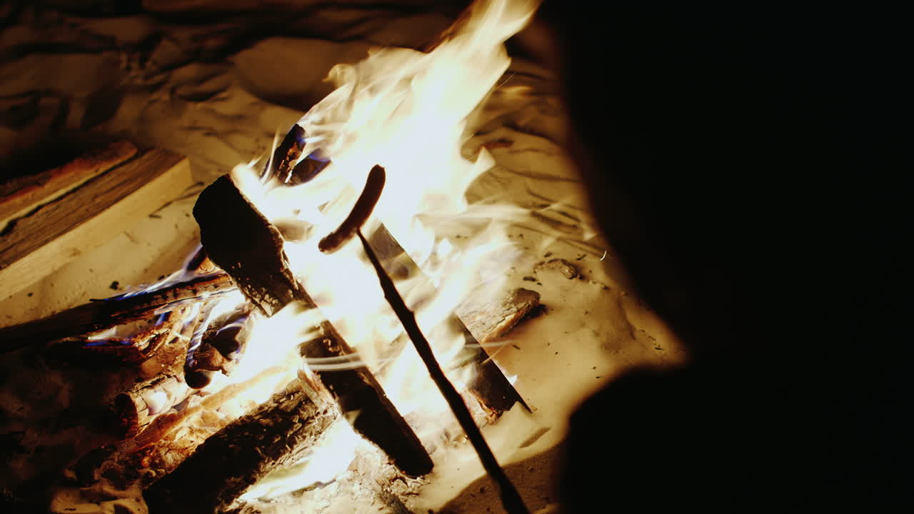 소시지와 함께 불 위에 막대기를 들고 손