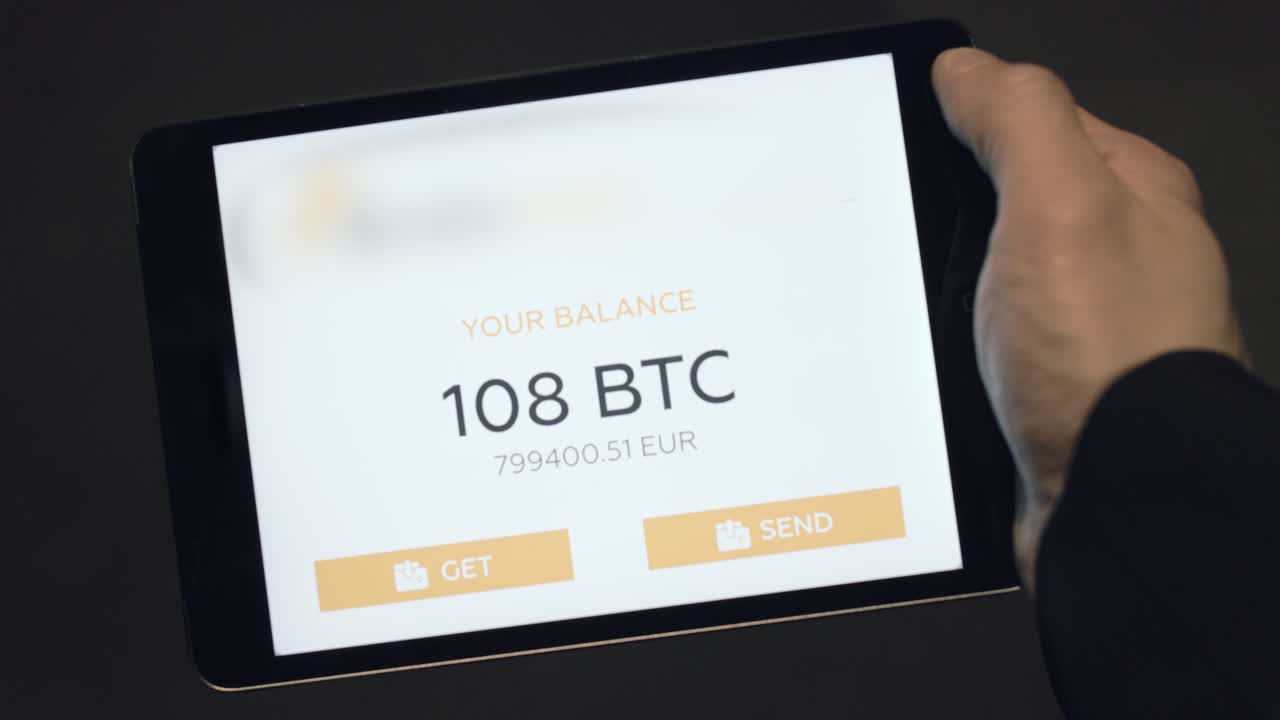 tableta en la mano que muestra el saldo de bitcoin