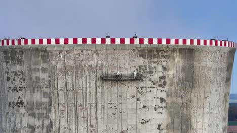 Aerial-view-of-people-in-full-body-suit-do-cooling-tower-maintenance