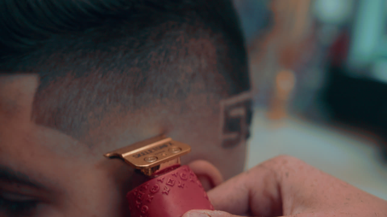 Amazing slow motion shot of a professional necee by a barber at his barbershop to a lat&iacute;n young man with shave