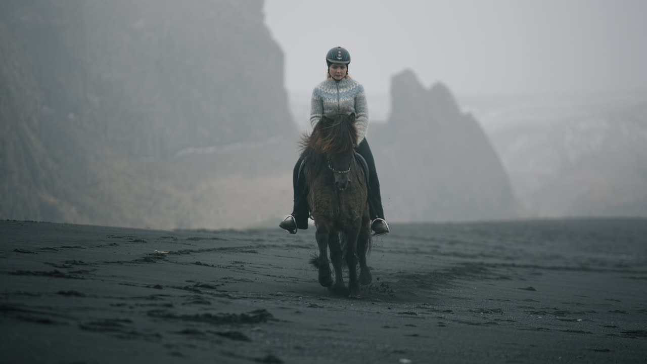 Woman Riding Icelandic Horse on Black Sand Beach in Iceland