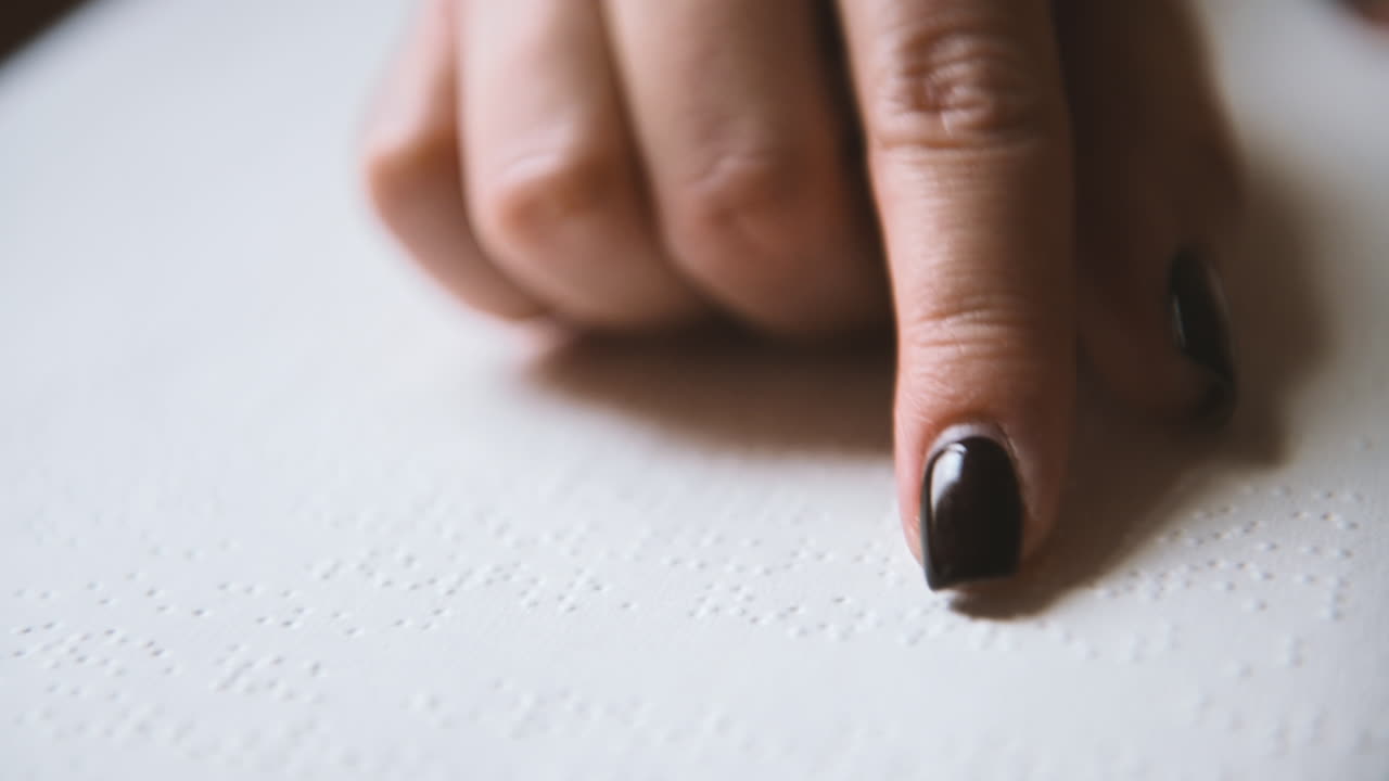 Close Up View Of Blind Woman Finger Touching The Letters Of A Braille Book