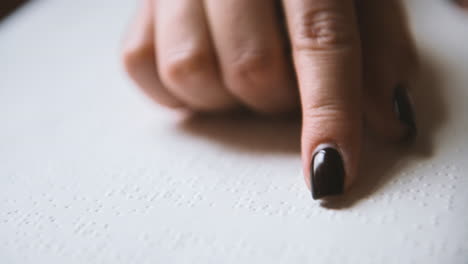 Nahaufnahme-Eines-Blinden-Frauenfingers,-Der-Die-Buchstaben-Eines-Braille-Buches-Berührt