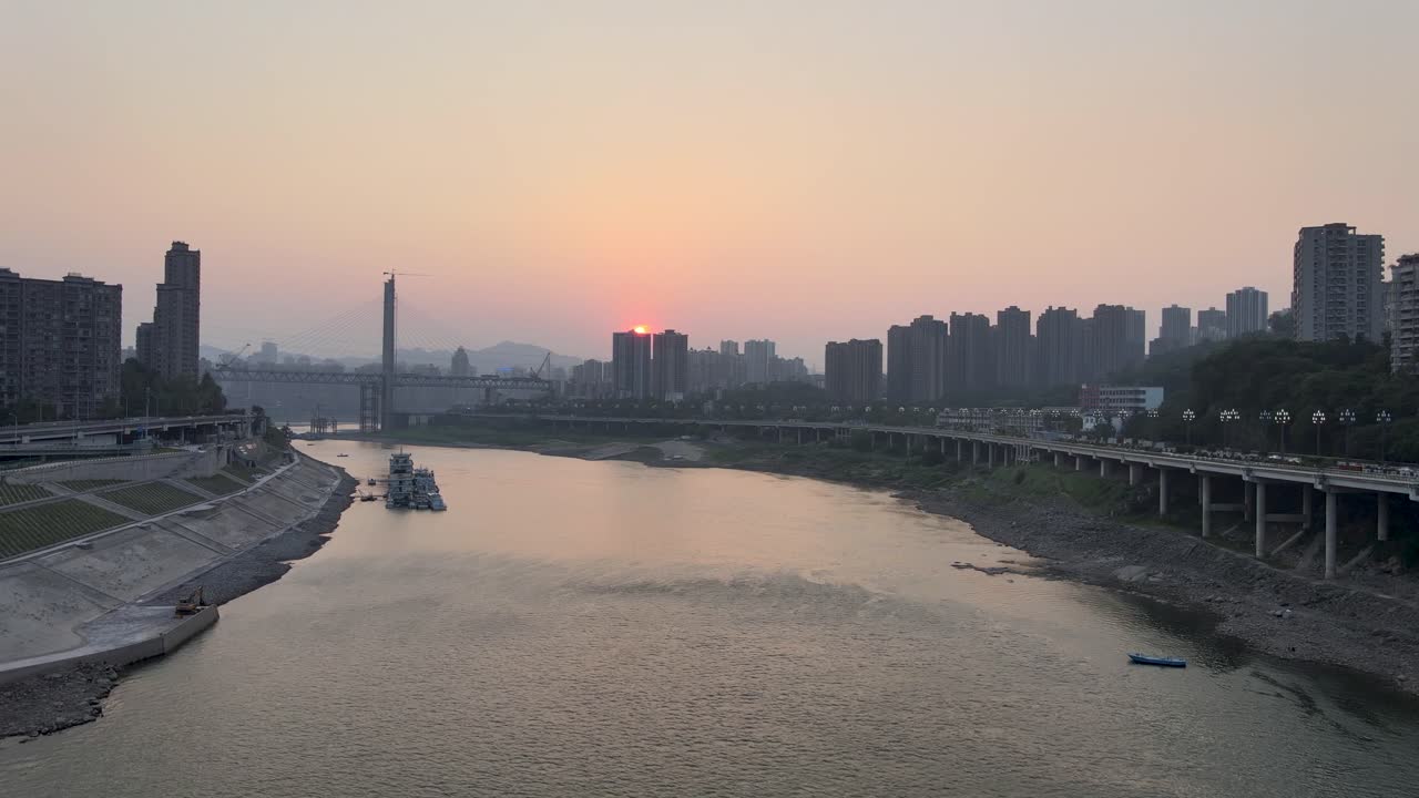 Beautiful sunset view of JiaLing river with constructing bridge in background, ChongQing, China