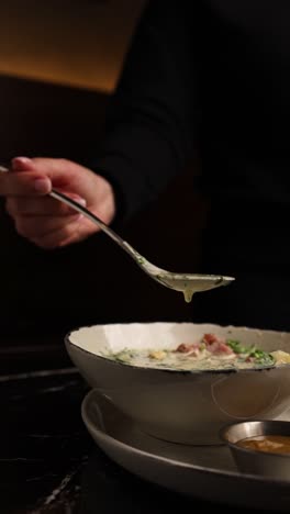 una mujer comiendo sopa.