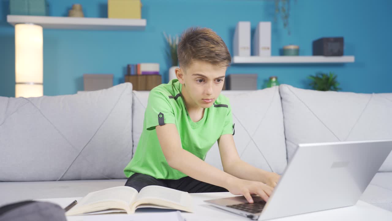 мальчик смотрит на ноутбук в замешательстве.