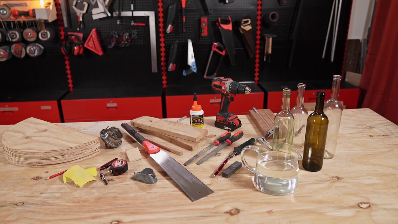 Wide shot of a carpenter workshop with woodworking tools, wooden boards, drill and DIY equipment arranged on a workbench. Professional craft, home improvement and construction concept.
