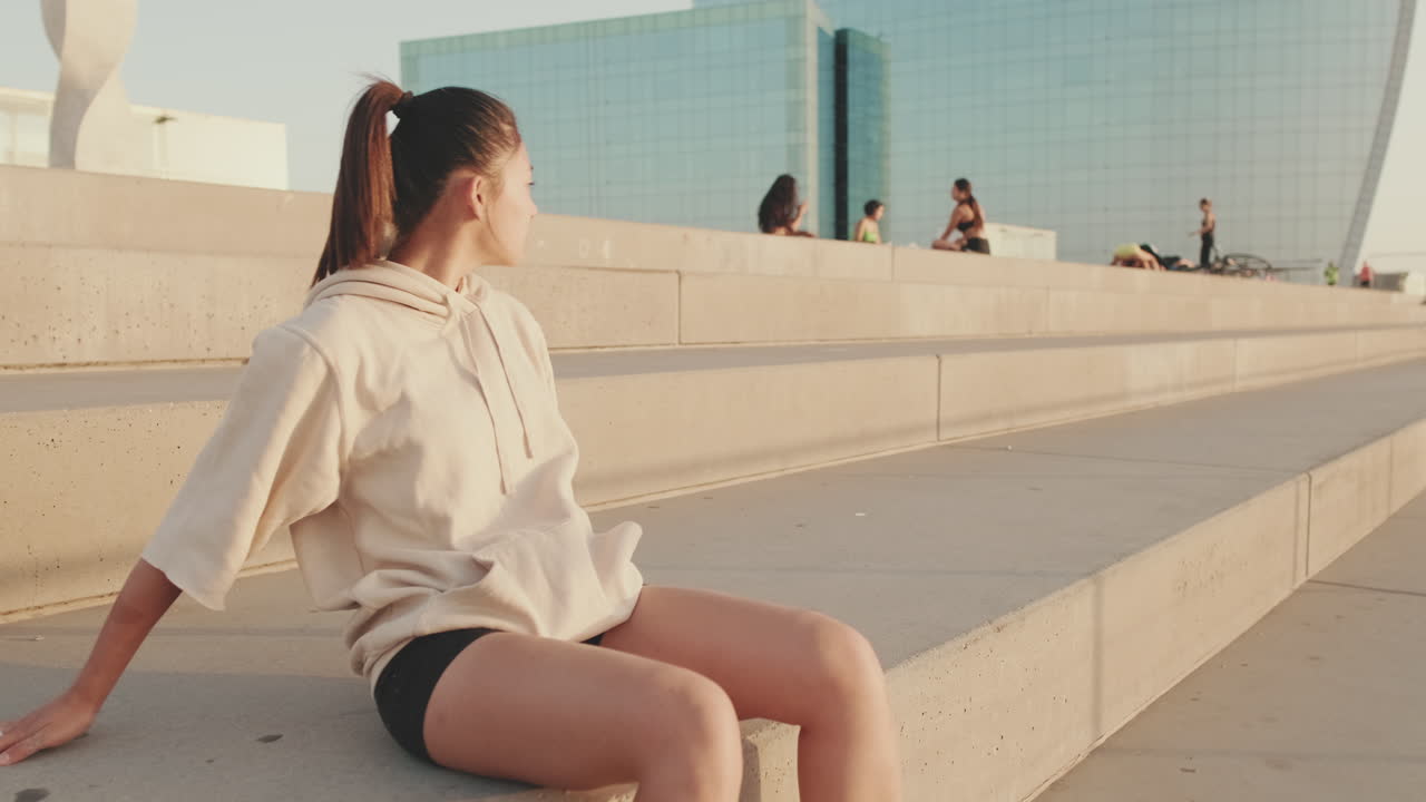 都会のコンクリートの階段に座る女性