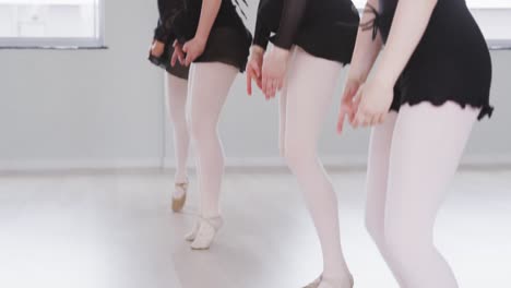 caucasian female ballet dancers practicing a dance routine during a ballet class