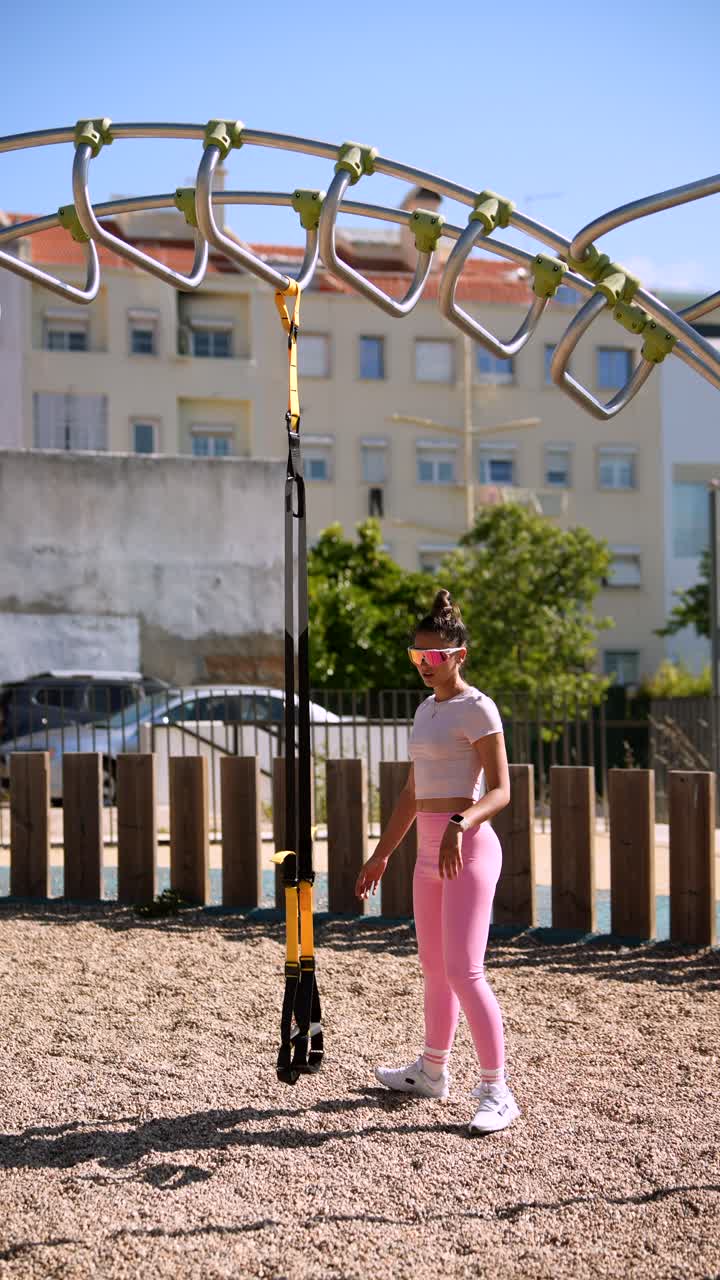 Woman doing outdoor workout with suspension trainer