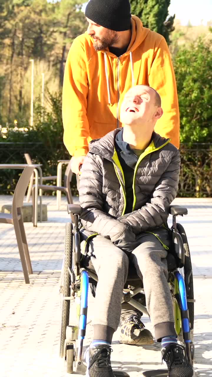 Man in wheelchair being pushed outdoors