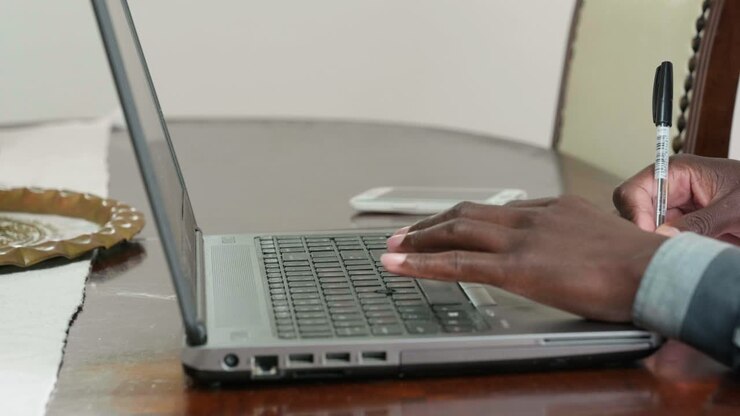 Homme africain travaillant sur un ordinateur portable depuis chez lui pendant le confinement