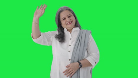 una mujer de negocios india feliz saludando y diciendo hola pantalla verde