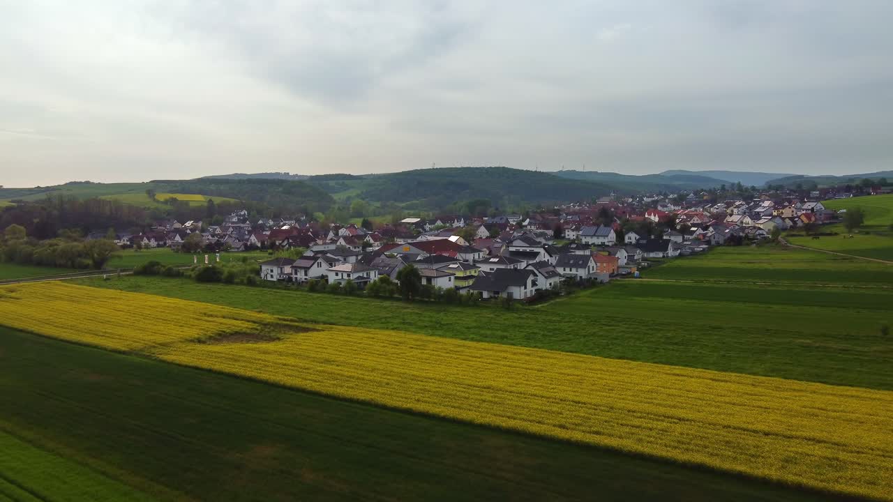 vida rural en un pequeño pueblo alemán en medio de un paisaje rural verde, drone hacia adelante