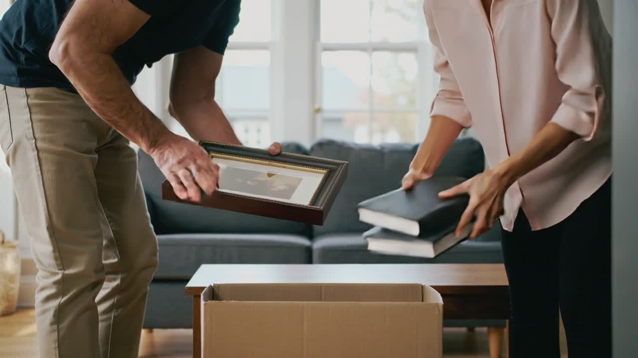 Opening box, partners in navy and pink organizing frame and albums on living room coffee table