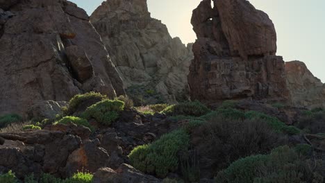 vista panorámica de formaciones rocosas con rayos de sol en el parque nacional del teide, inclinación dinámica hacia arriba