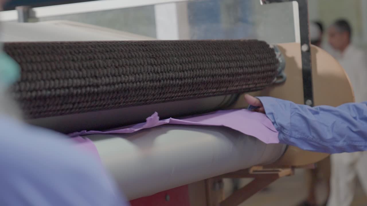 Textile Factory Workers Flattening Tanned Hides In A Industrial Leather Press Machine.