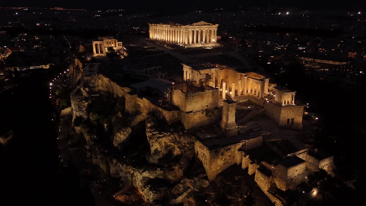 Athens, Aerial view of Beautifully illuminated Acropolis at night, circle pan left slowly,Full view of Panthenon,Erechthenion and entrance of Acropolis in shimmering lights