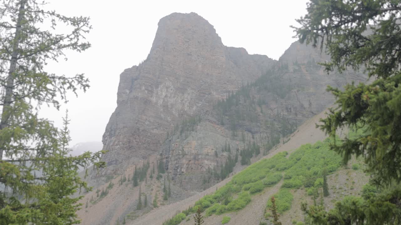 View of the mountain range surrounding Moraine Lake in Banff National Park Alberta on a slightly foggy afternoon.