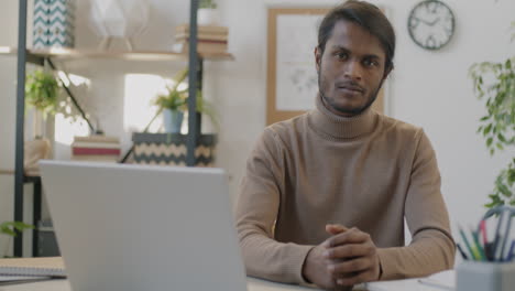 man sitting at a desk working on a laptop
