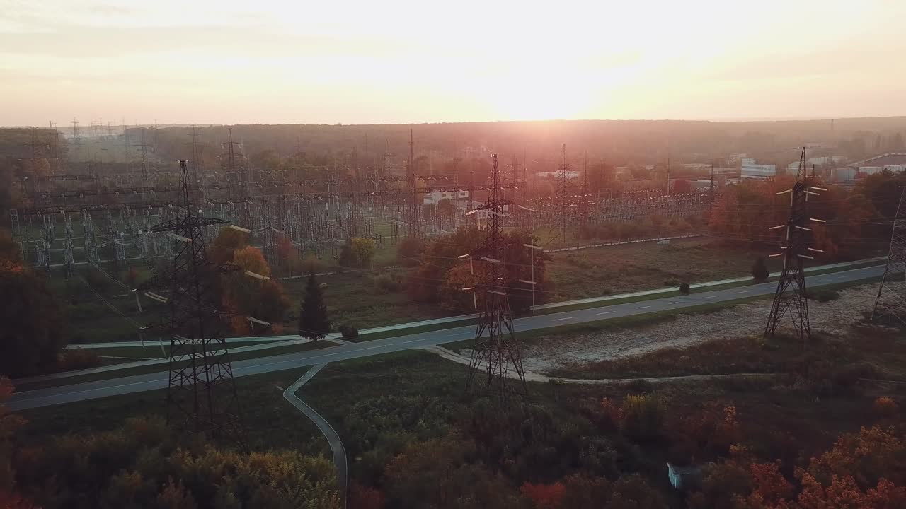 view of the structure of high-voltage lines outside the city at sunset. Camera motion back. Aerial view
