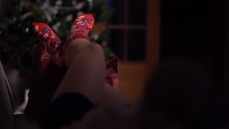 Mujer-Joven-Vistiendo-Calcetines-De-Lana-Caliente-Junto-A-La-Chimenea-En-La-Víspera-De-Navidad-7