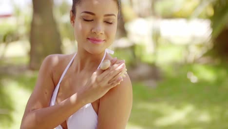 Happy-woman-using-exfoliating-brush-on-skin