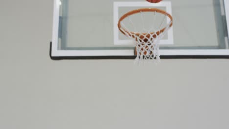 diverse female basketball team training with male coach in indoor court, in slow motion