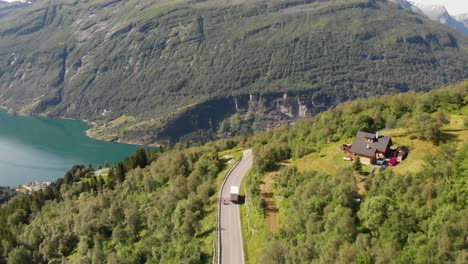 two motocycles filmed from above on a road in front of the geirangerfjord in norway