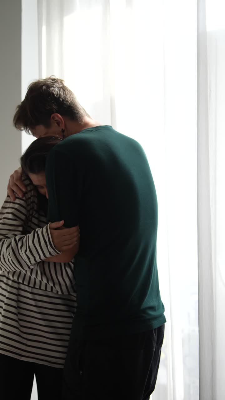 pareja interactuando cerca de una ventana