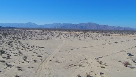 View-of-a-drone-flying-over-a-field-to-a-mountain