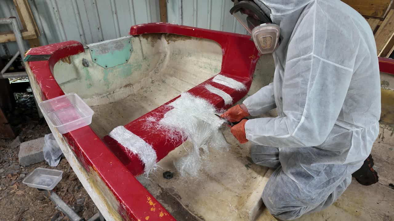 Cortar fibra de vidrio para reparar un barco antiguo de fibra de vidrio