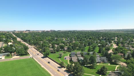 drone aerial over neighborhood with cars driving on road during summer