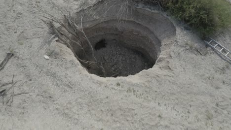 Aerial-shot-of-wild-boar-sitting-in-a-sinkhole-in-dead-sea-desert-Israel,-drone-shot