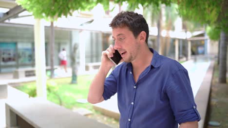 hombre hablando en un teléfono inteligente en el parque de la compañía