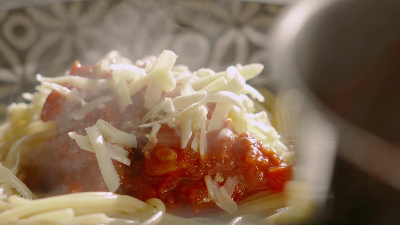 Spaghetti Bolognese Pasta with Grated Cheese alongside Cooking Pot with Steam Rising in Slow Motion. Healthy Cooking Kitchen to Plate Concept Visualisation 4K