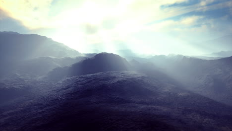 Majestic sunlight breaking through clouds over a serene mountain landscape
