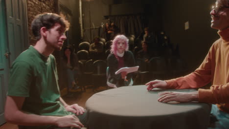 actors rehearsing on stage with female theater director