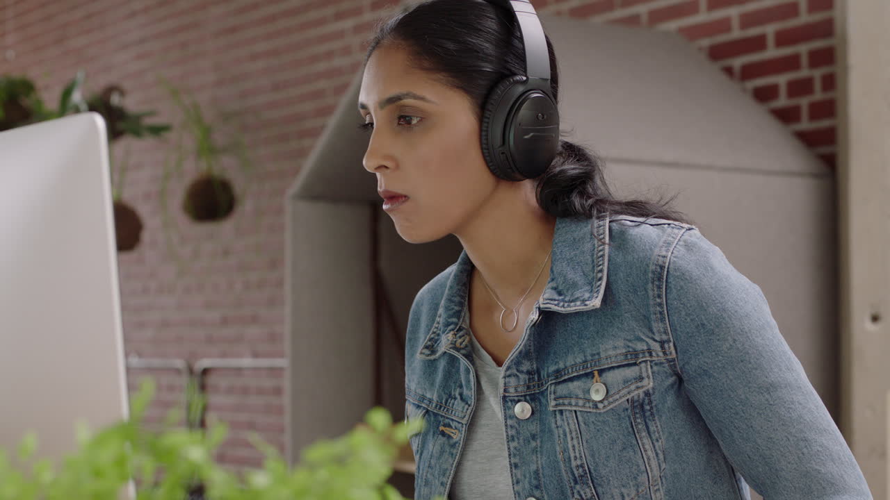 hermosa mujer de negocios india comiendo comida china relajándose en lucnh rompiendo disfrutando de una comida saludable trabajando usando computadora en una oficina moderna escuchando música usando auriculares