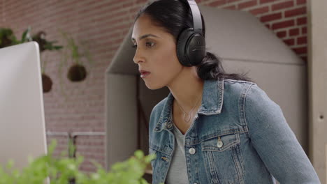 hermosa mujer de negocios india comiendo comida china relajándose en lucnh rompiendo disfrutando de una comida saludable trabajando usando computadora en una oficina moderna escuchando música usando auriculares