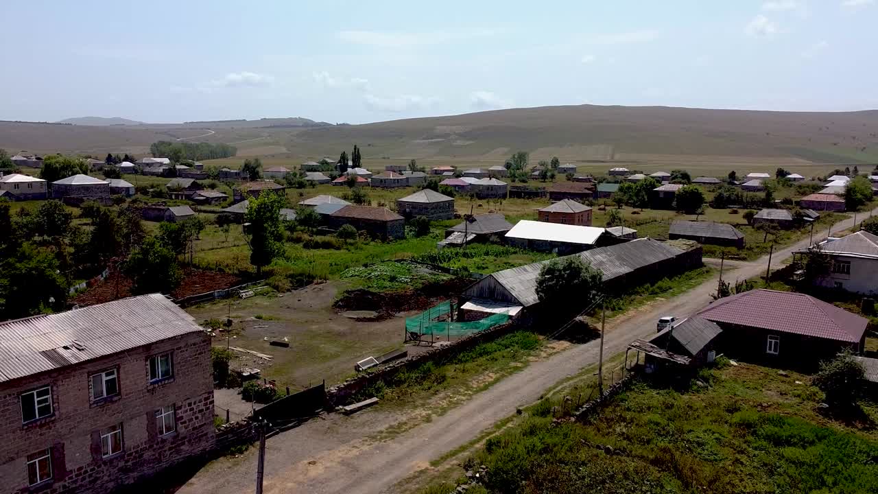 This clip showcases a serene village in Armenia, surrounded by rolling hills. Homes are scattered across the landscape, highlighting local architecture and vibrant nature
