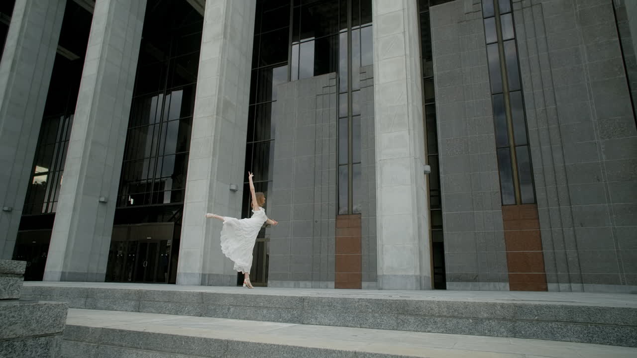 Woman in a White Dress Walking in Front of a Modern Building