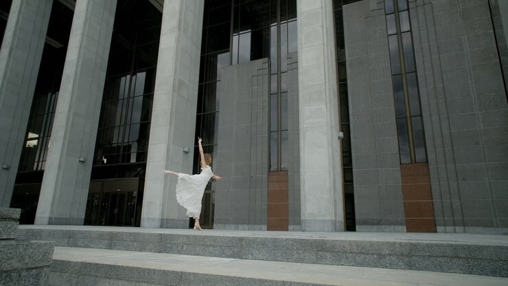 Woman in a White Dress Walking in Front of a Modern Building
