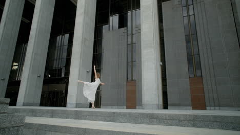 woman in a white dress walking in front of a modern building