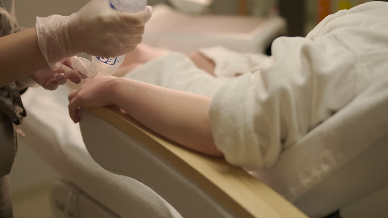 Specialist Applying Gel to Client's Arm for Treatment