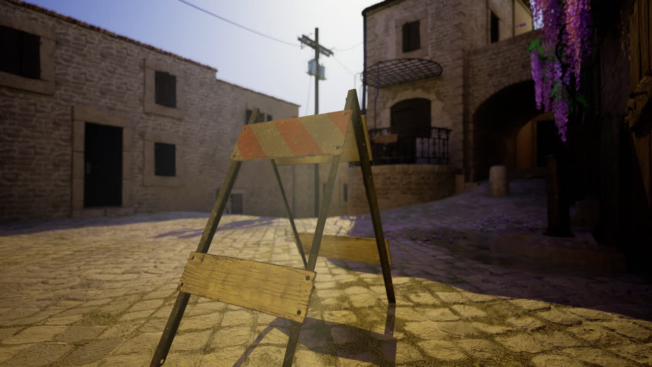 Construction barrier blocks pathway in village street during sunny day