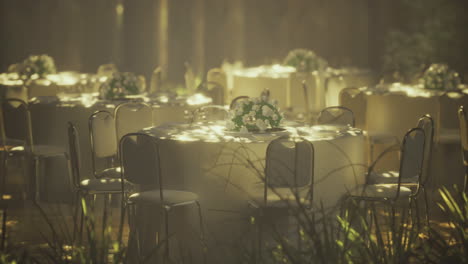 outdoor event setup with tables and floral arrangements in sunlight