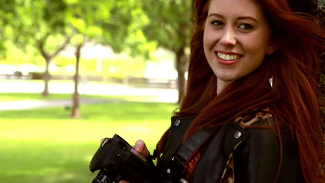 Pretty-redhead-taking-a-photo-in-the-park