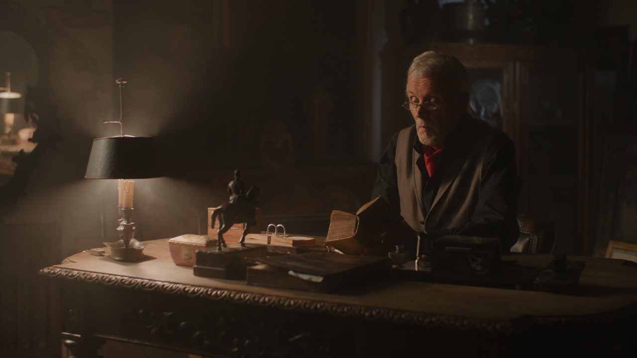 Old passionate man writes down a note in his office at night