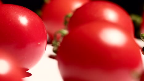 close up of cherry tomatoes rotating over dark background